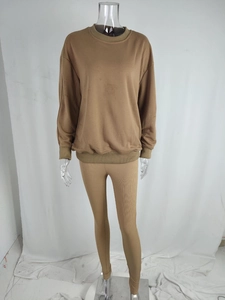 Detail view of brown two-piece tracksuit featuring ribbed texture and crew neck sweatshirt
