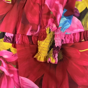Détail des poignets élastiques smokés avec bords à volants sur une robe fleurie