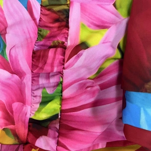 Détail d'une robe à imprimé fleuri rose avec texture plissée et volants cousus
