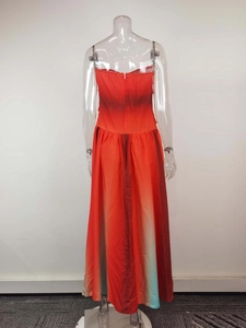 Detailed view of ombre strapless dress with red to teal gradient and A-line pleated skirt