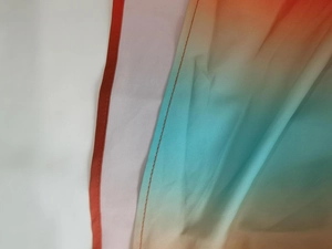 Detail of the gradient fabric from orange to blue with precise orange stitching