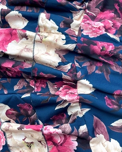 Detail of floral printed fabric with ruffles and high-quality stitching on long skirt