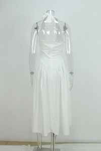 Detail of white halter neck maxi dress featuring back tie bow and pleated skirt detail