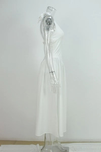 Detail of white halter neck maxi dress with backless design and tied bow at the neckline