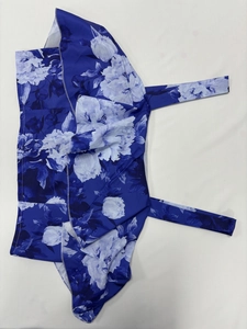 Detail of floral printed fabric with waist ties and white overlock stitching finish