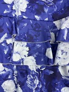 Close-up of blue floral print ruffles with detailed stitching on a tiered maxi dress