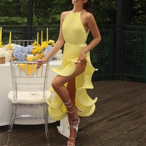 Detail of high-slit pleated bright yellow halter dress with spiral ruffle hemline