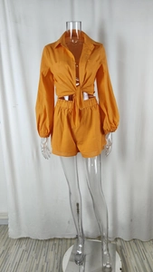 Detail of orange long sleeve shirt with front tie knot and elastic waist shorts