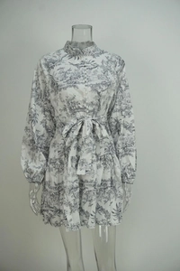 Détail de robe fleurie à col montant avec ourlet à volants et ceinture à nouer