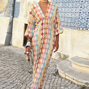 Detail of bohemian maxi dress featuring vibrant colorful geometric prints and lantern sleeves