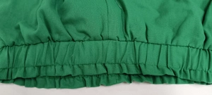 Close-up of elastic pleated waist detail on a green casual cotton linen set