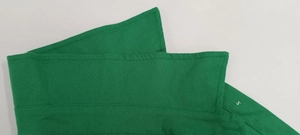 Detailed close-up of dark green shirt collar showing textured fabric and stitching