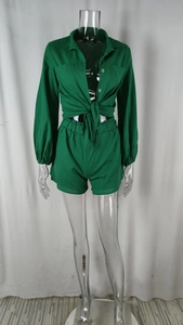 Detail of green long-sleeve button-down shirt with front pockets and waist knot tied design
