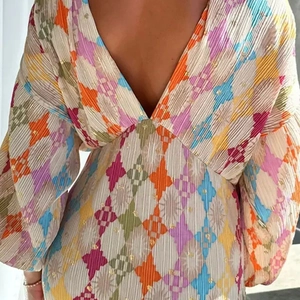Detail of colorful geometric diamond pattern dress with pleated fabric and gold glitter