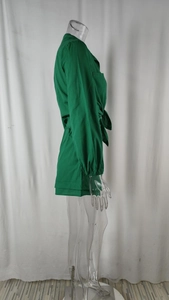 Detail view of green long-sleeved jumpsuit with lapel collar and waist tie design