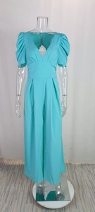 Detail of V-neck mint blue jumpsuit featuring puffy sleeves and high-waisted wide leg cut