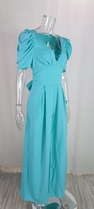 Detail of teal V-neck jumpsuit featuring puffed sleeves and elegant wide-leg trousers cut
