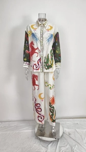Detail van bohemien set met totemprints van draken en zonnen op broek met wijde pijpen