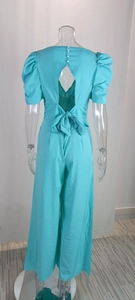 Detailed back view of mint green jumpsuit with open back cutout and bow tie detail