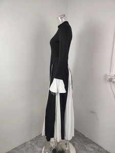 Detail view of the elegant black and white contrast dress with ruffed white sleeve cuffs