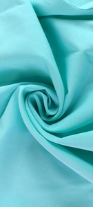 Detailed macro view of mint green plain weave fabric showing soft texture and drape