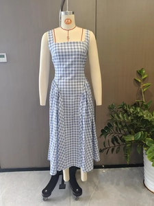 Détail de la robe à carreaux bleus avec encolure carrée et taille cintrée sur mannequin