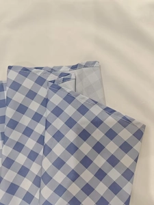 Détail du tissu à carreaux vichy bleu et blanc avec coutures soignées et texture coton