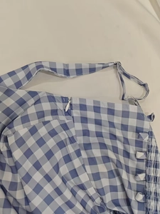 Détail de robe à carreaux bleus avec fermeture éclair invisible et fines bretelles