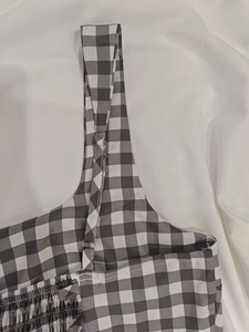 Détail d'une robe vichy avec bretelles réglables et textures de smocks élastiques