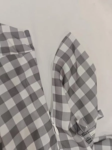 Détail de la fermeture éclair invisible sur une robe à carreaux vichy gris et blanc