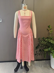 Détail de robe à carreaux rose avec encolure carrée et taille plissée élégante