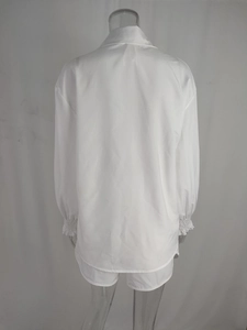 Dettaglio retro camicia bianca a maniche lunghe con polsini elastici e pantaloncini