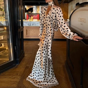 Vintage polka dot V-neck midi dress with puff sleeves and lace trim in a bistro setting
