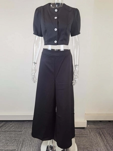 Front view of black two-piece set featuring short-sleeve shirt and wide-leg trousers