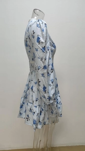 Close-up of floral print mini dress with white lace waist trim and ruffled hem detail