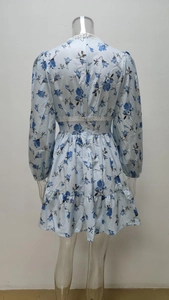 Detail view of white lace trim on a light blue floral long sleeve mini dress