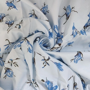 Close-up of elegant blue floral chiffon fabric with delicate rose print in spiral fold