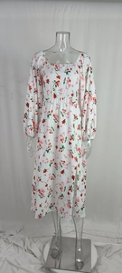 Détail du col carré et de la taille élastique d'une robe blanche à fleurs