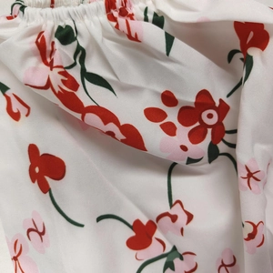 Gros plan détaillé du tissu à fleurs blanches et rouges avec texture plissée élastique