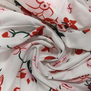 Détail du tissu à fleurs avec des fleurs rouges et roses éclatantes sur fond blanc