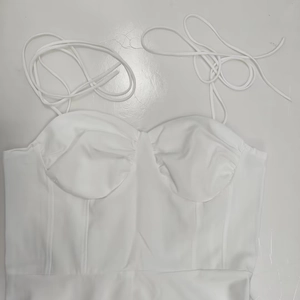 Détail d'un haut corset blanc avec baleines structurées et fines bretelles spaghetti