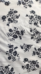 Détail du motif floral vintage sur un tissu de robe tissé léger et blanc cassé