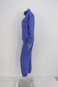 Detail of blue two-piece tracksuit showing side stitching and elastic cuffs on set
