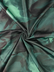 Close-up of abstract floral print fabric with green silk texture and twist detail