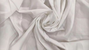 Détail du tissu en mousseline blanche avec drapé doux et texture pliée en spirale