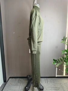 Detail of olive green two-piece track suit with half-zip stand collar and ribbed cuffs
