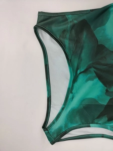 Detail of green tropical leaf print dress featuring high-quality double-needle stitching