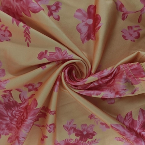 Detailed macro view showing yellow floral print fabric with pink flowers and stitched edge