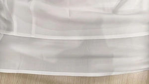 Détail de la robe blanche sans manches montrant les doubles coutures et la finition