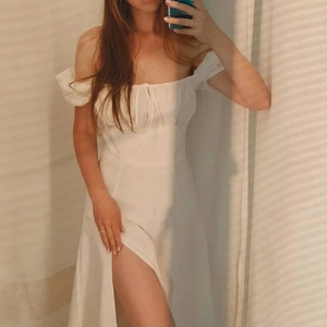 Close-up of white off-shoulder dress featuring drawstring bust detail and side slit design